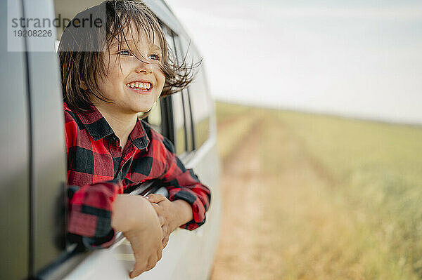 Smiling boy looking out of car window