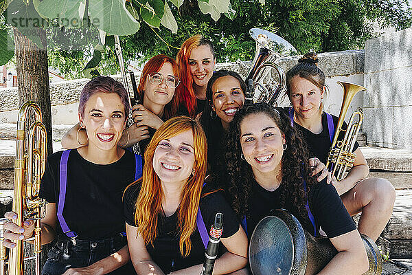 Fröhliche Frauen-Volksmusikgruppe sitzt zusammen mit Instrumenten