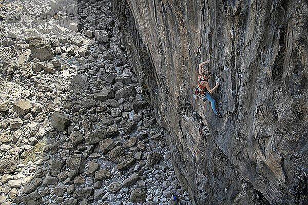 Entschlossene Frau klettert mit Seil auf den Berg