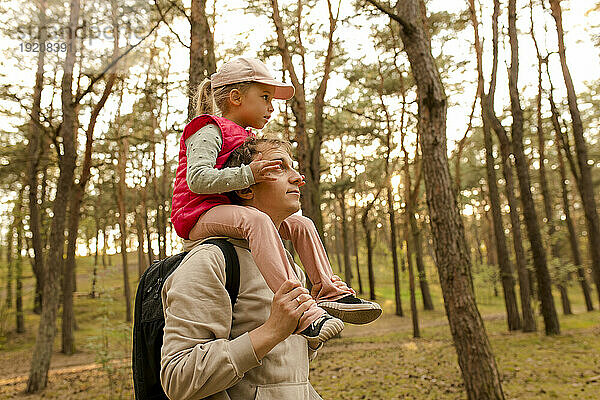 Vater trägt Tochter auf der Schulter im Wald