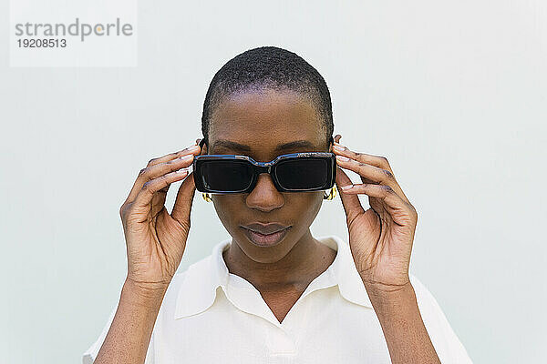 Young woman wearing sunglasses against white background