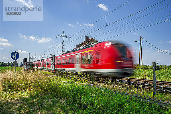 Germany  North Rhine Westphalia  Beckrath  Blurred motion of red passenger train