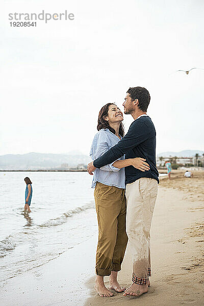 Glückliches Paar  das sich am Strand umarmt