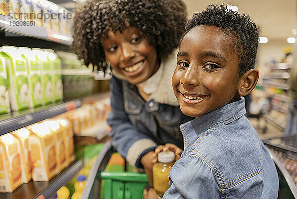 Glücklicher Junge mit Mutter im Supermarkt