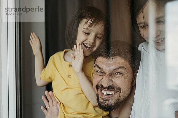 Smiling father and sons having fun at home