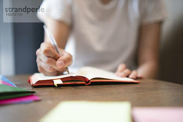 Geschäftsfrau schreibt Tagebuch auf dem Tisch