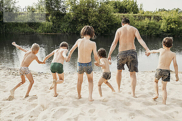 Vater mit Kindern genießt es am Flussufer