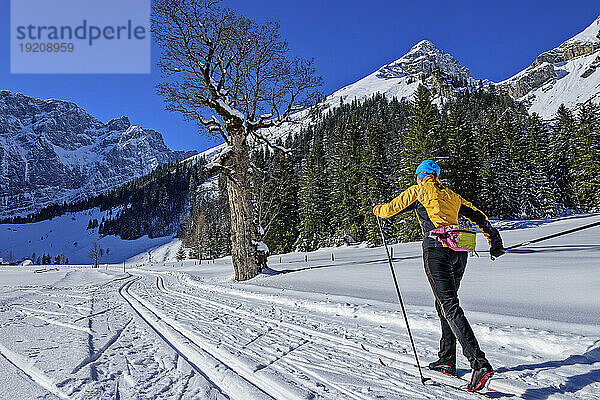Frau beim Skifahren in verschneiter Landschaft in Richtung Karwendelgebirge