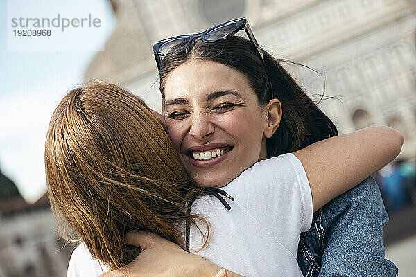Lächelnde Frau umarmt Freund in der Stadt