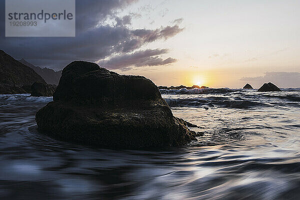 Rock amidst sea at sunset in Playa de Benijo