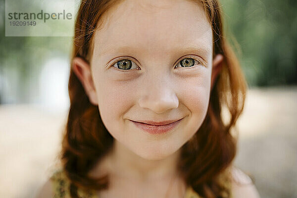Lächelndes rothaariges Mädchen im Park