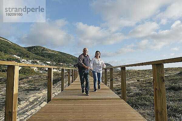 Glückliches älteres Paar läuft auf der Promenade
