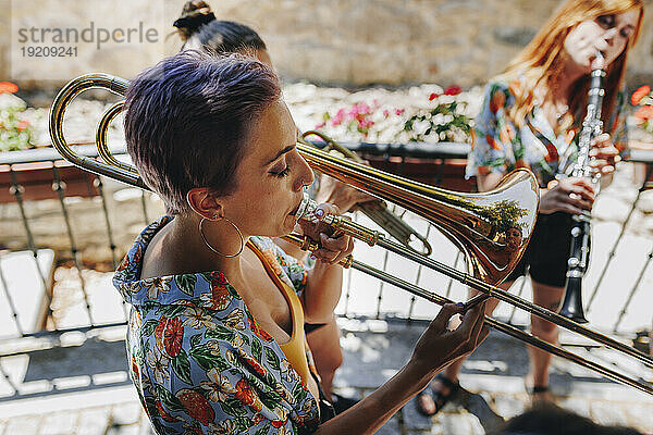 Woman blowing trumpet with folk music group