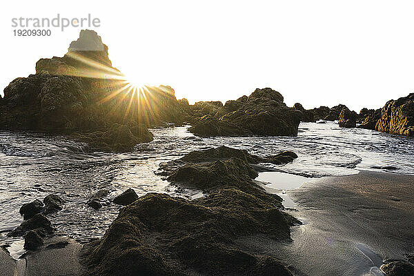Strand mit Felsen bei Sonnenuntergang
