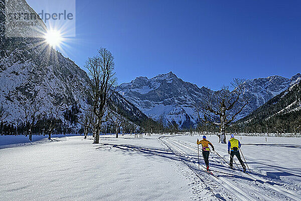 Paar beim Skifahren in der schneebedeckten Landschaft in Richtung Karwendelgebirge