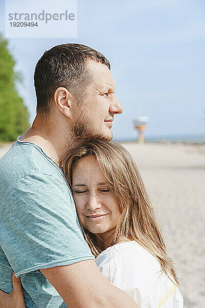 Glückliche Paare  die sich am Strand umarmen