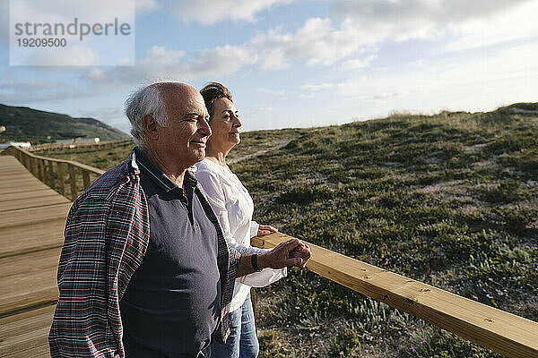 Nachdenkliches älteres Paar steht am Geländer auf der Promenade