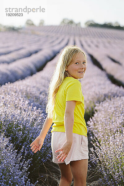 Verspieltes Mädchen verbringt Freizeit im Lavendelfeld