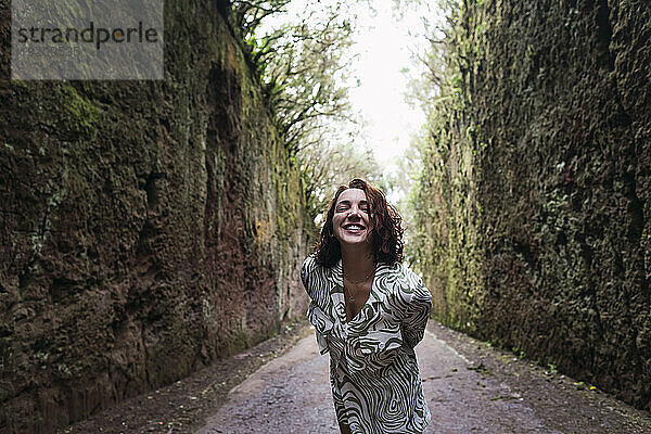Smiling woman standing on footpath
