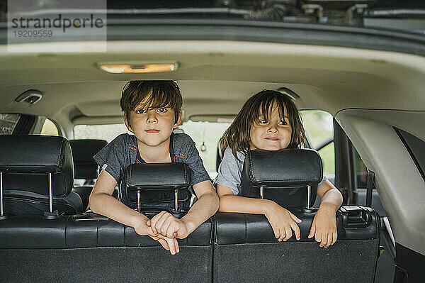 Lächelnde Jungen verbringen ihre Freizeit im Auto