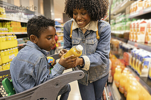 Glückliche Mutter kauft mit Sohn im Supermarkt ein