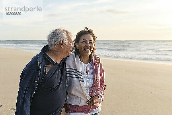 Glückliche ältere Frau genießt Urlaub mit Mann am Strand