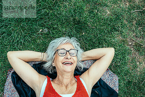 Smiling businesswoman lying on grass