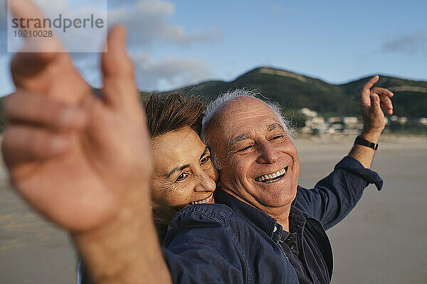 Glückliches älteres Paar  das gemeinsam Spaß am Strand hat