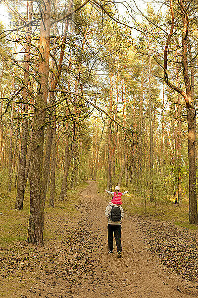 Father and daughter exploring forest