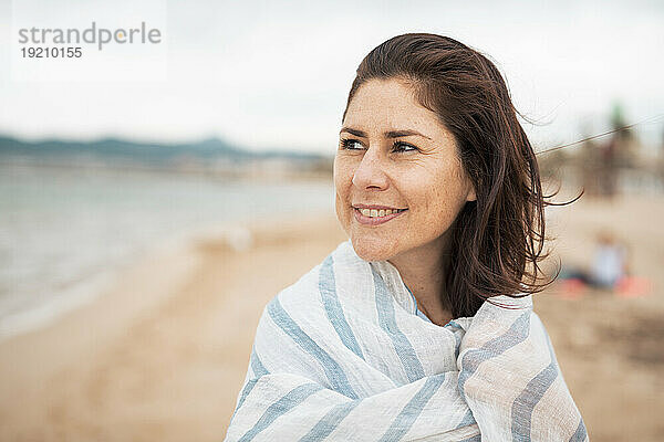 Nachdenkliche Frau mit Schal am Strand