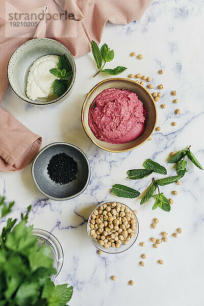 Beetroot hummus with mint leaves on table