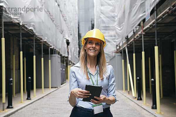 Nachdenklicher Ingenieur hält Tablet-PC in der Hand und träumt auf der Baustelle