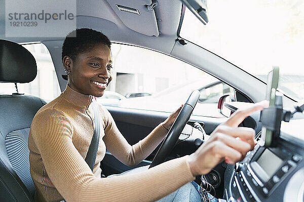 Glückliche Frau benutzt Smartphone im Auto