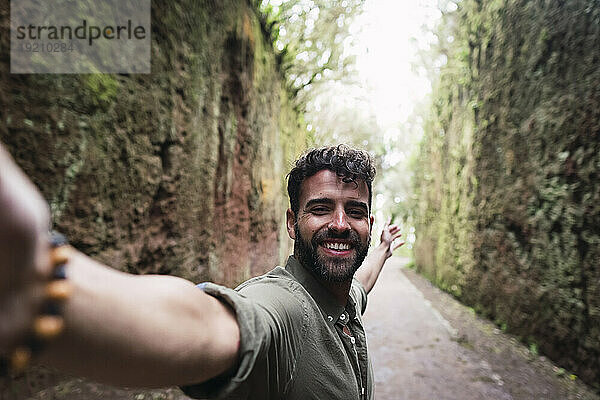 Lächelnder Mann macht Selfie am Fußweg