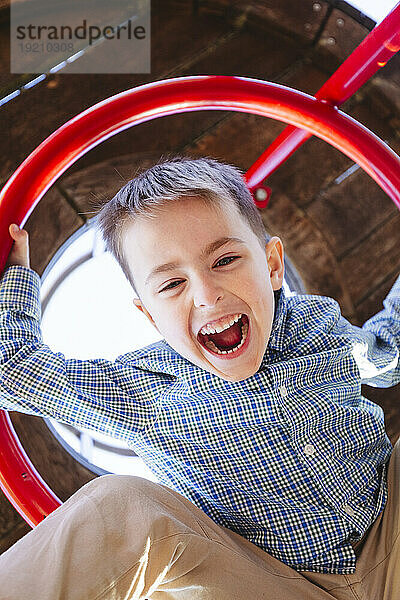 Cheerful boy screaming at playground