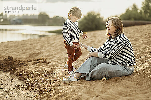 Nachdenkliche Mutter und Sohn am Strand