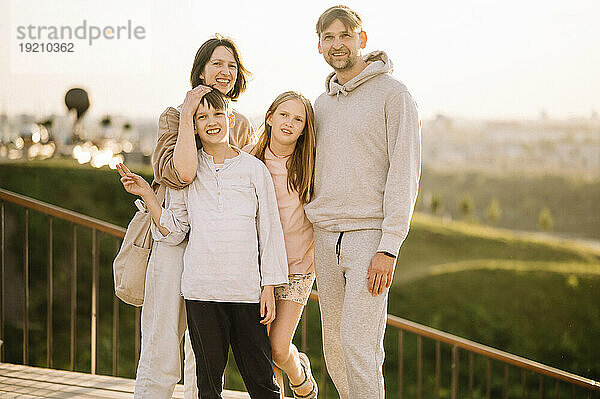 Lächelnde Familie steht auf der Brücke
