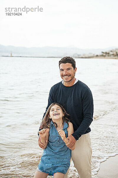 Glücklicher Vater und Tochter genießen den Strand