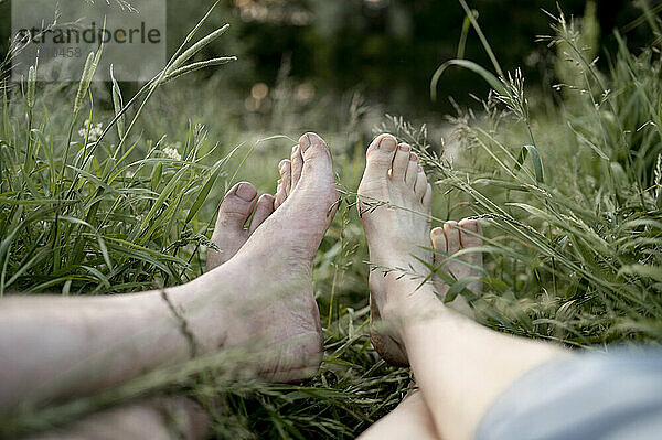 Couple relaxing together on grass in field