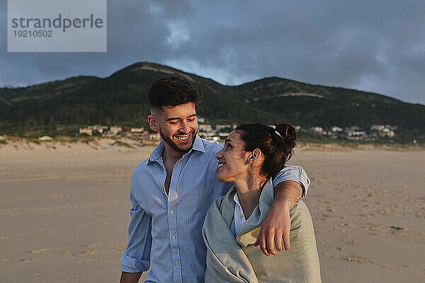 Glückliches junges Paar verbringt seine Freizeit am Strand