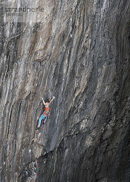 Frau klettert mit Seil auf den Berg