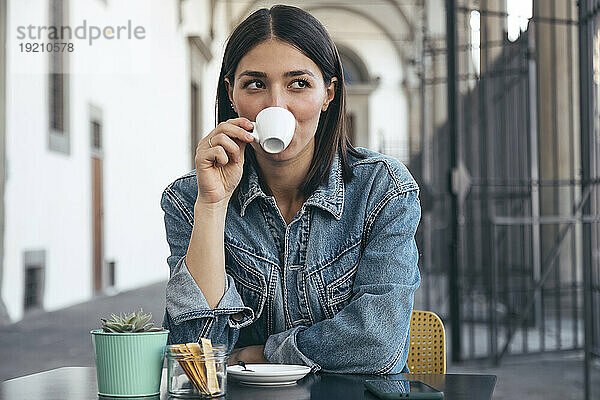 Glückliche Frau trinkt Kaffee im Café