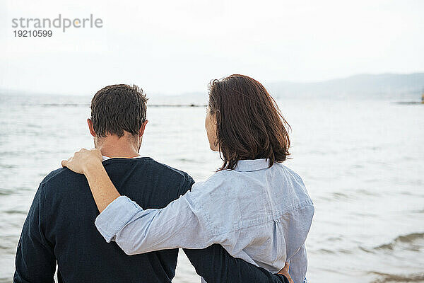 Paar steht zusammen vor dem Meer