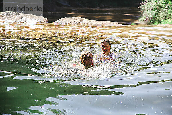 Mutter und Sohn schwimmen im Fluss