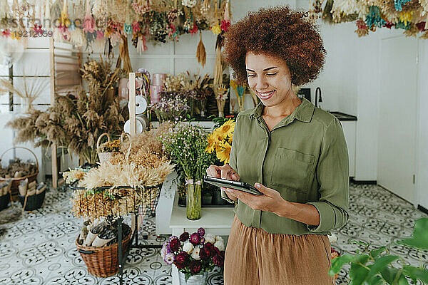 Lächelnder Florist mit Tablet-PC im Blumenladen