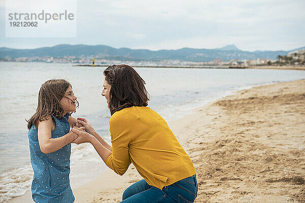 Glückliche Tochter und Mutter  die Spaß am Strand haben