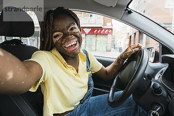 Lächelnde Frau macht Selfie im Auto