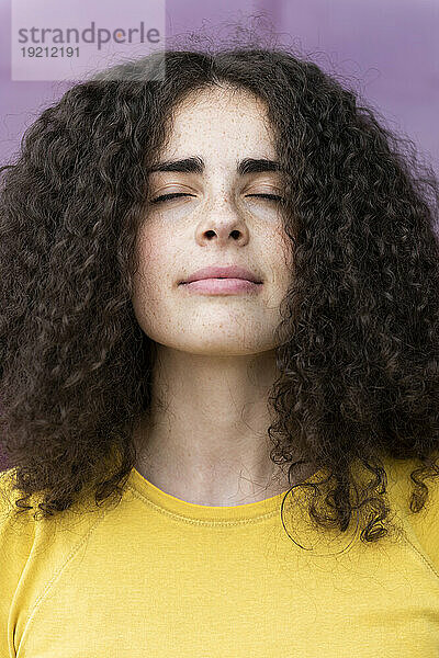 Curly haired woman with eyes closed