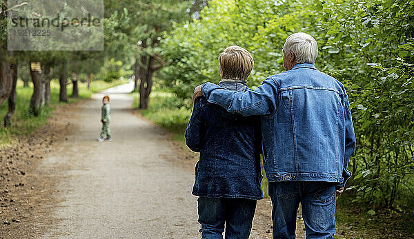 Affectionate elderly couple walking together in forest