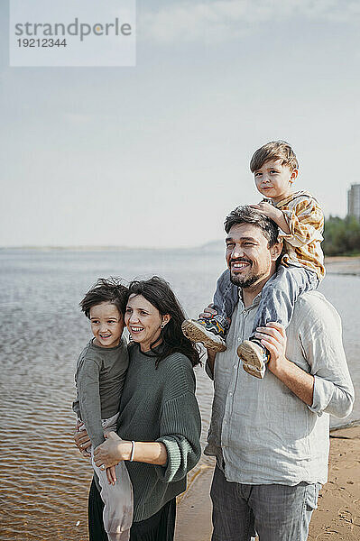Glückliche Eltern mit Kindern am Strand